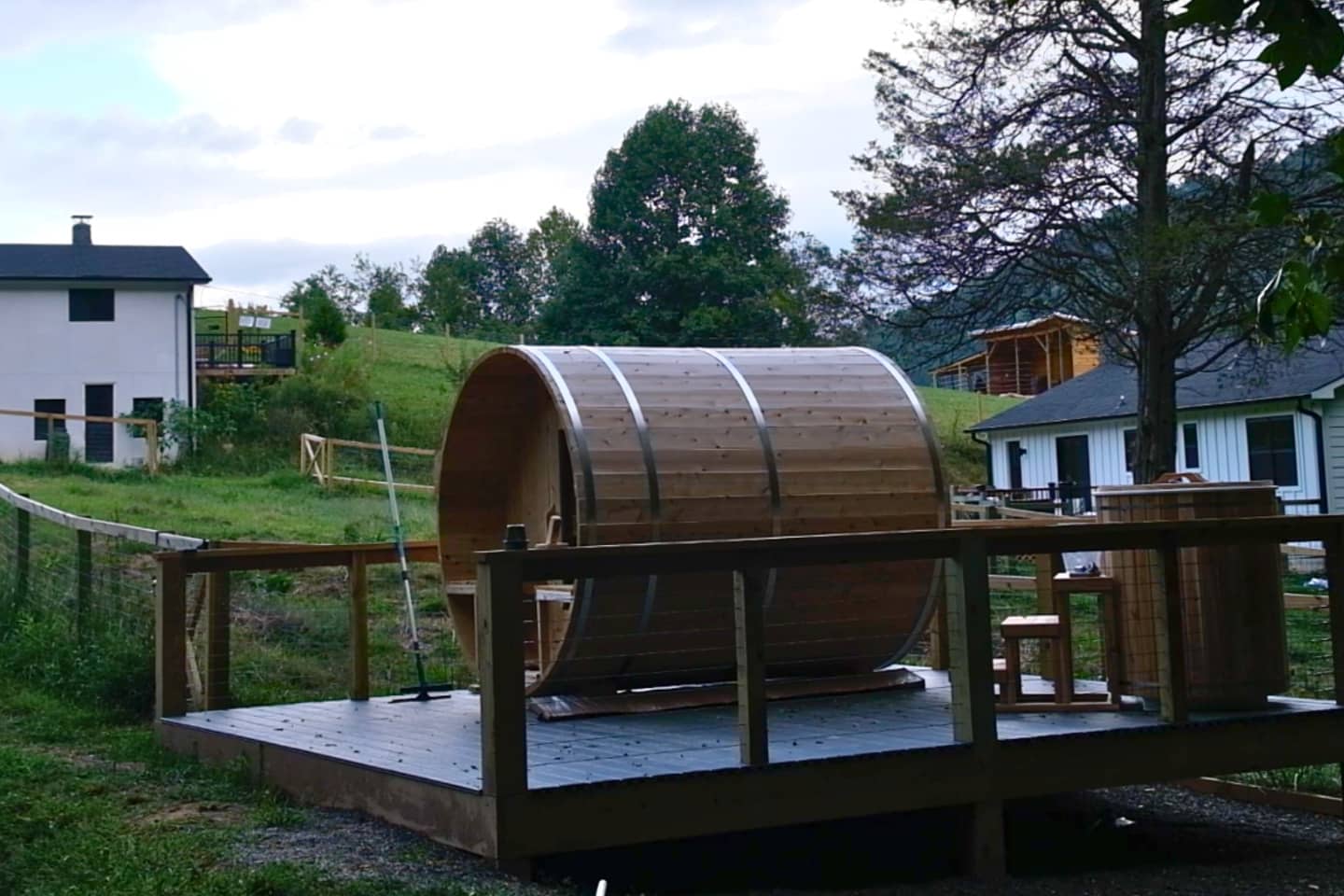 A wooden hot tub sits on top of a wooden deck.