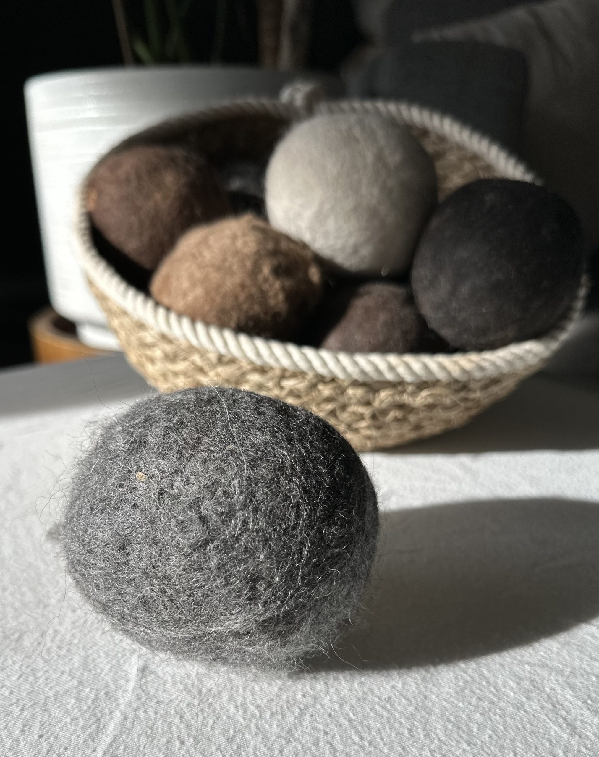 Felted Dryer Balls in a basket on a table.