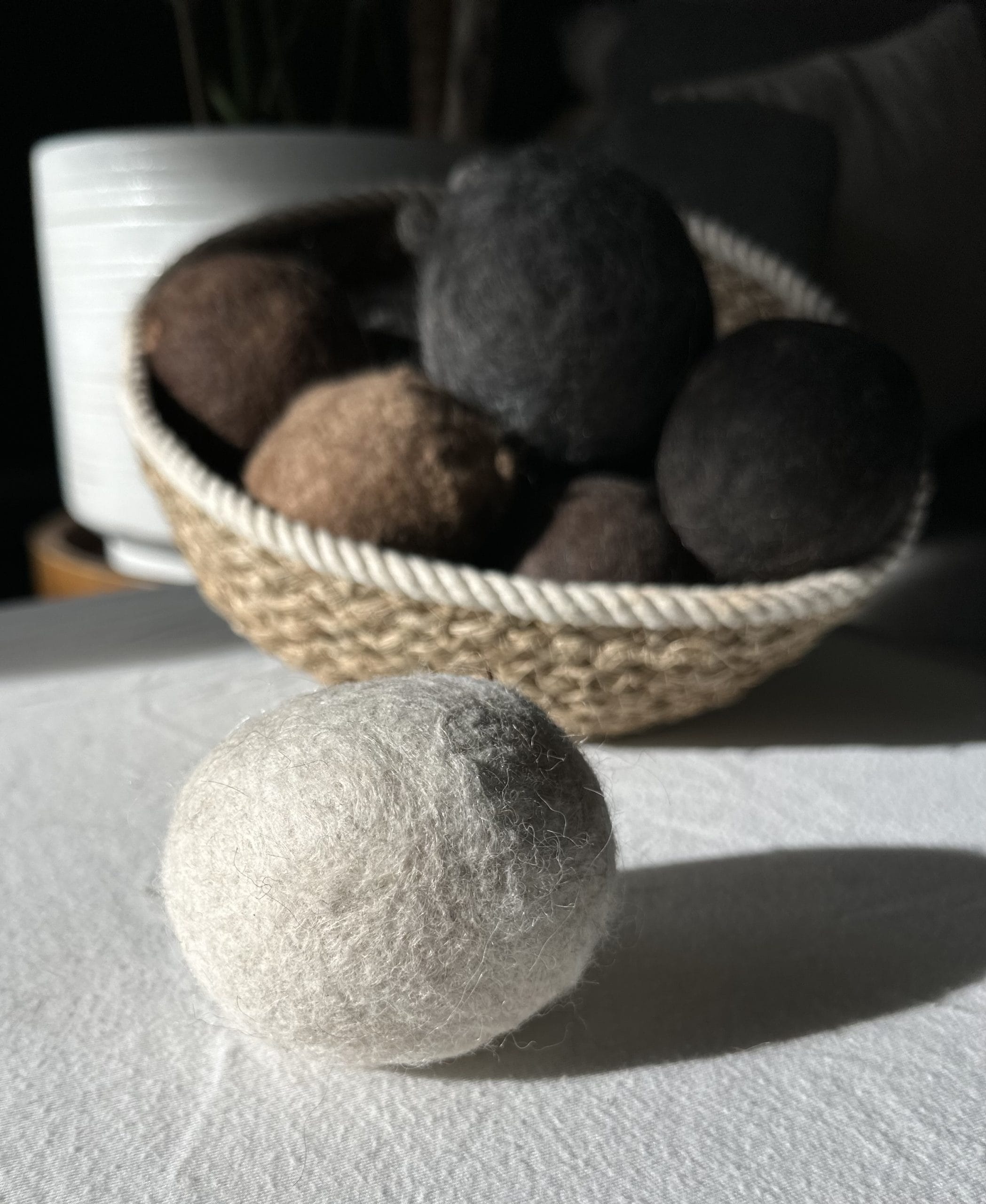 Felted Dryer Balls in a basket on a table.