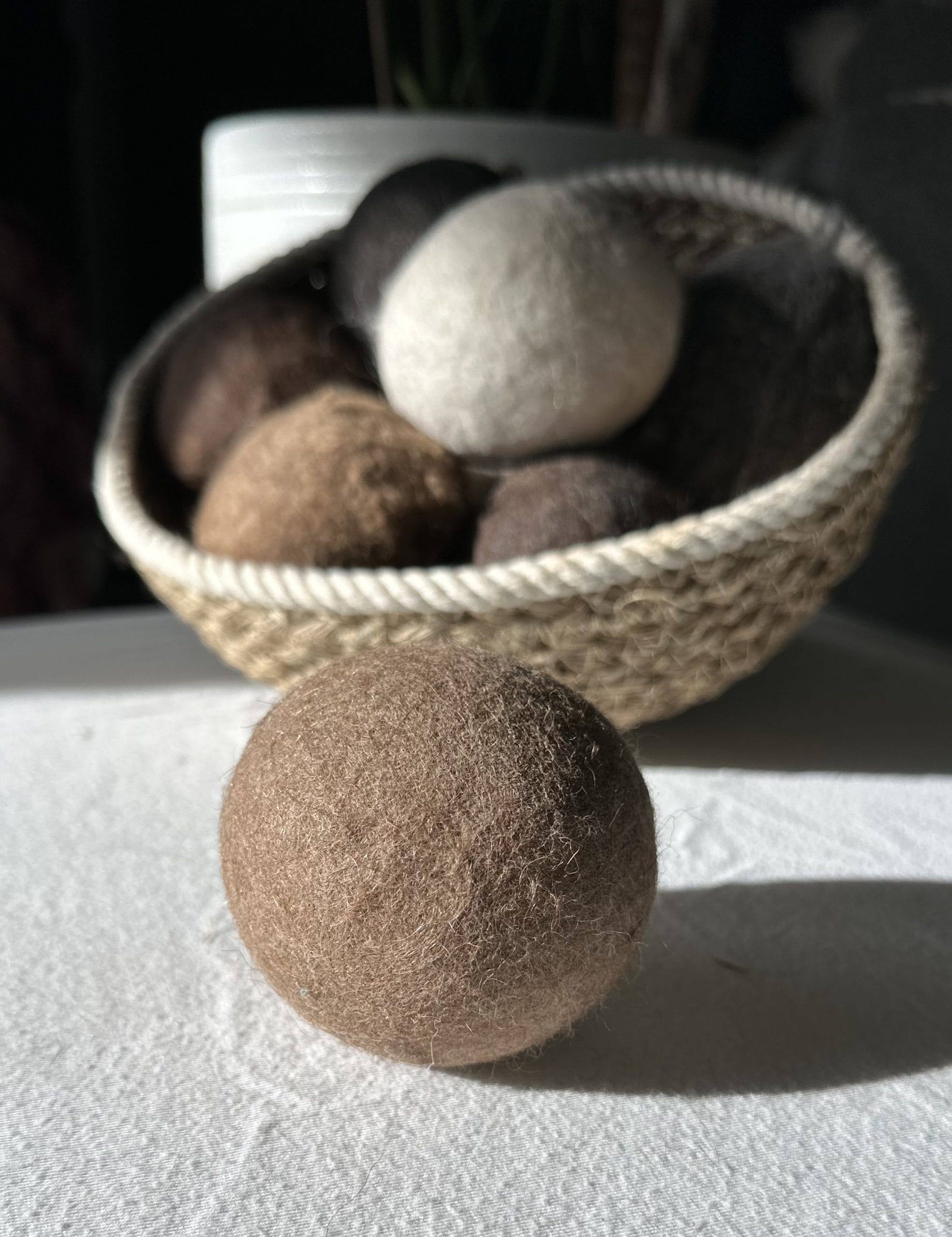 Felted Dryer Balls in a basket on a table.