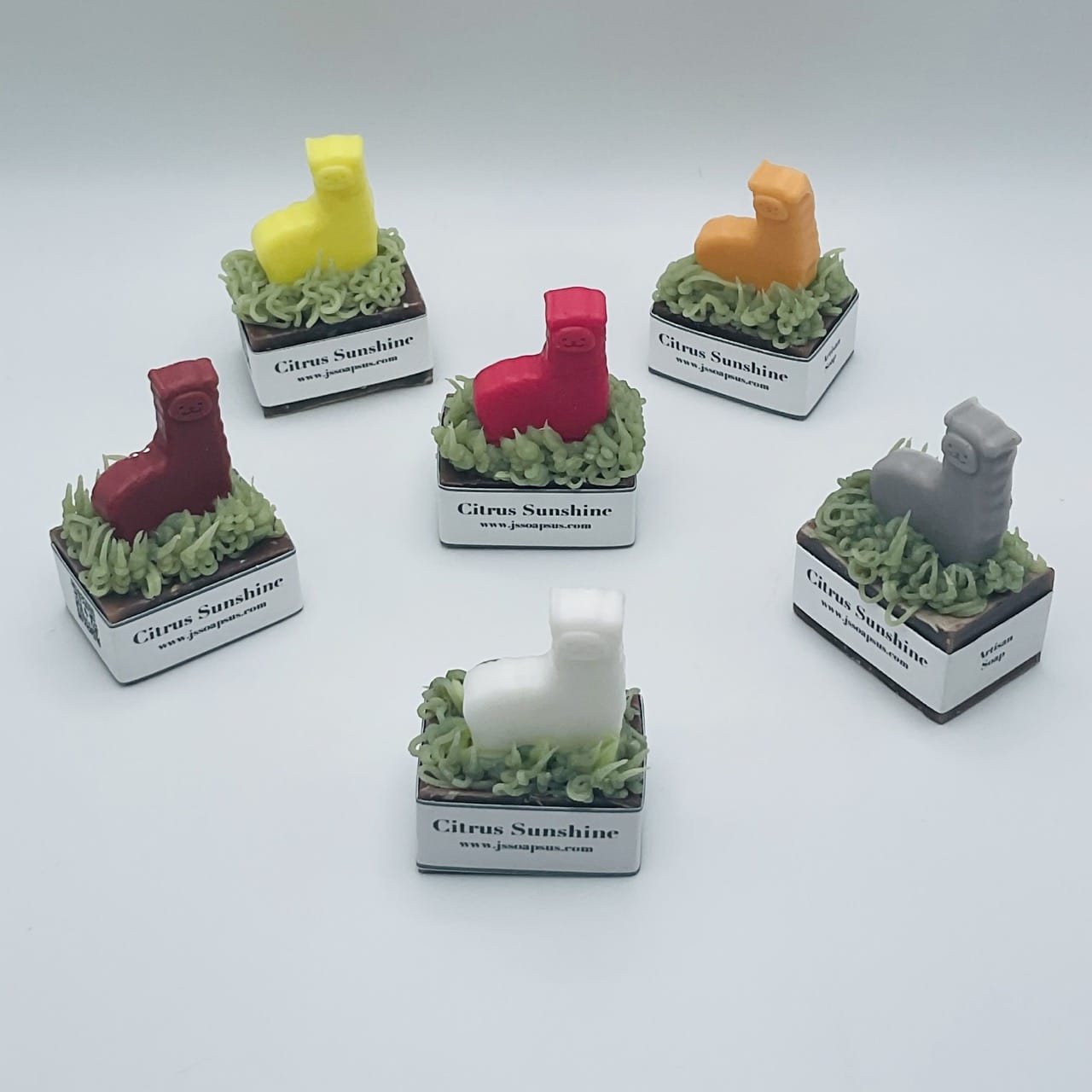 A group of small candles with different colored Locally-sourced Soap on them.