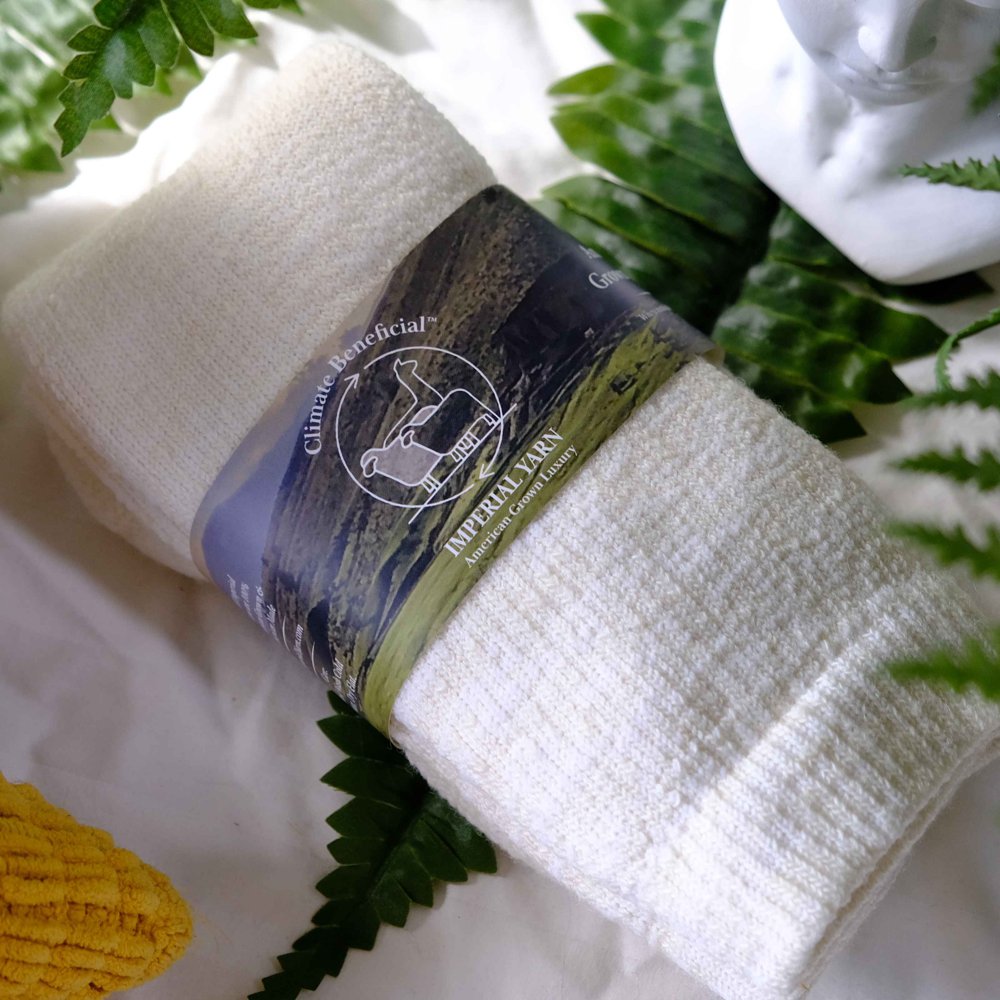 A white towel laying on a bed with ferns.