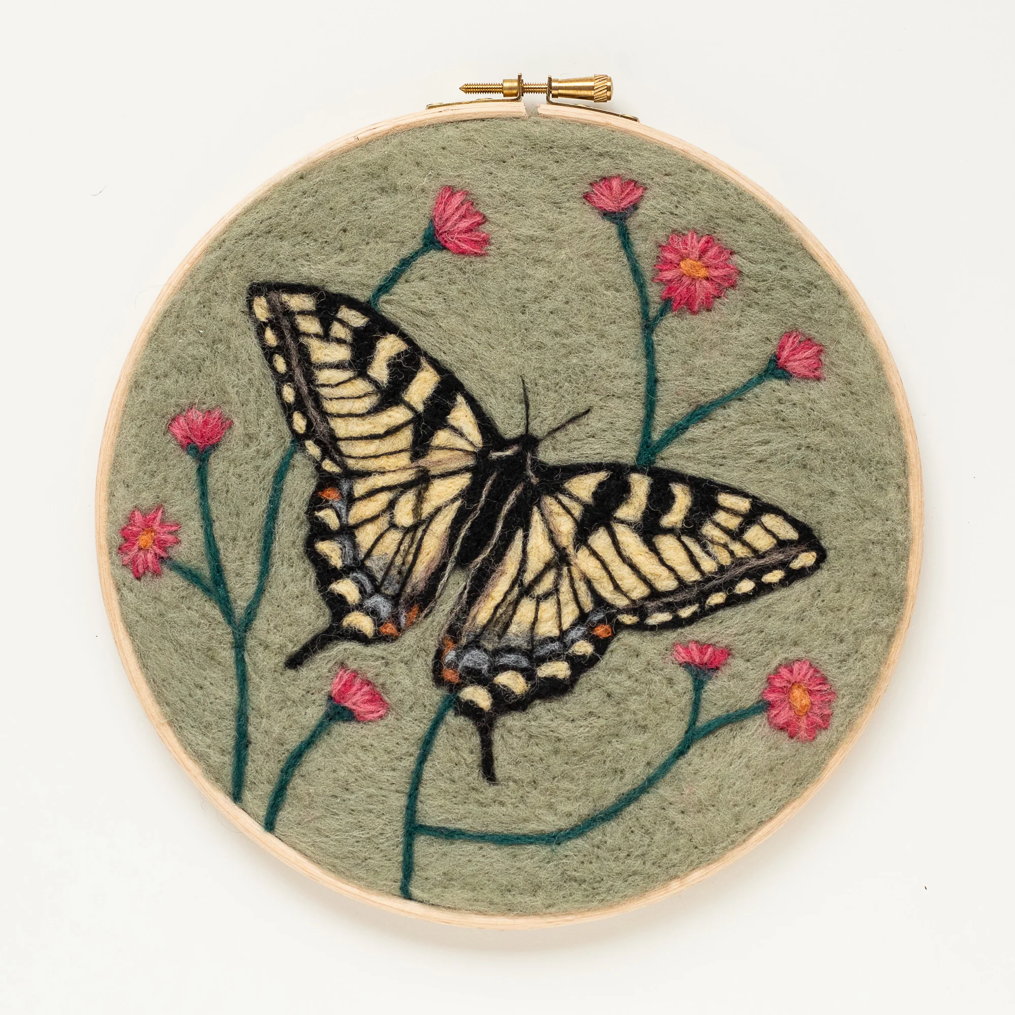 A butterfly needle felting kit is embroidered on a green hoop.