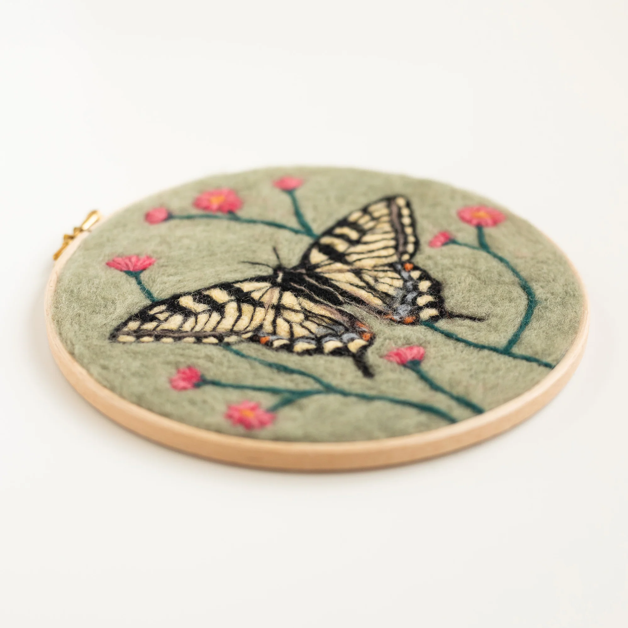 A Butterfly Needle Felting Kit is embroidered on a green hoop.