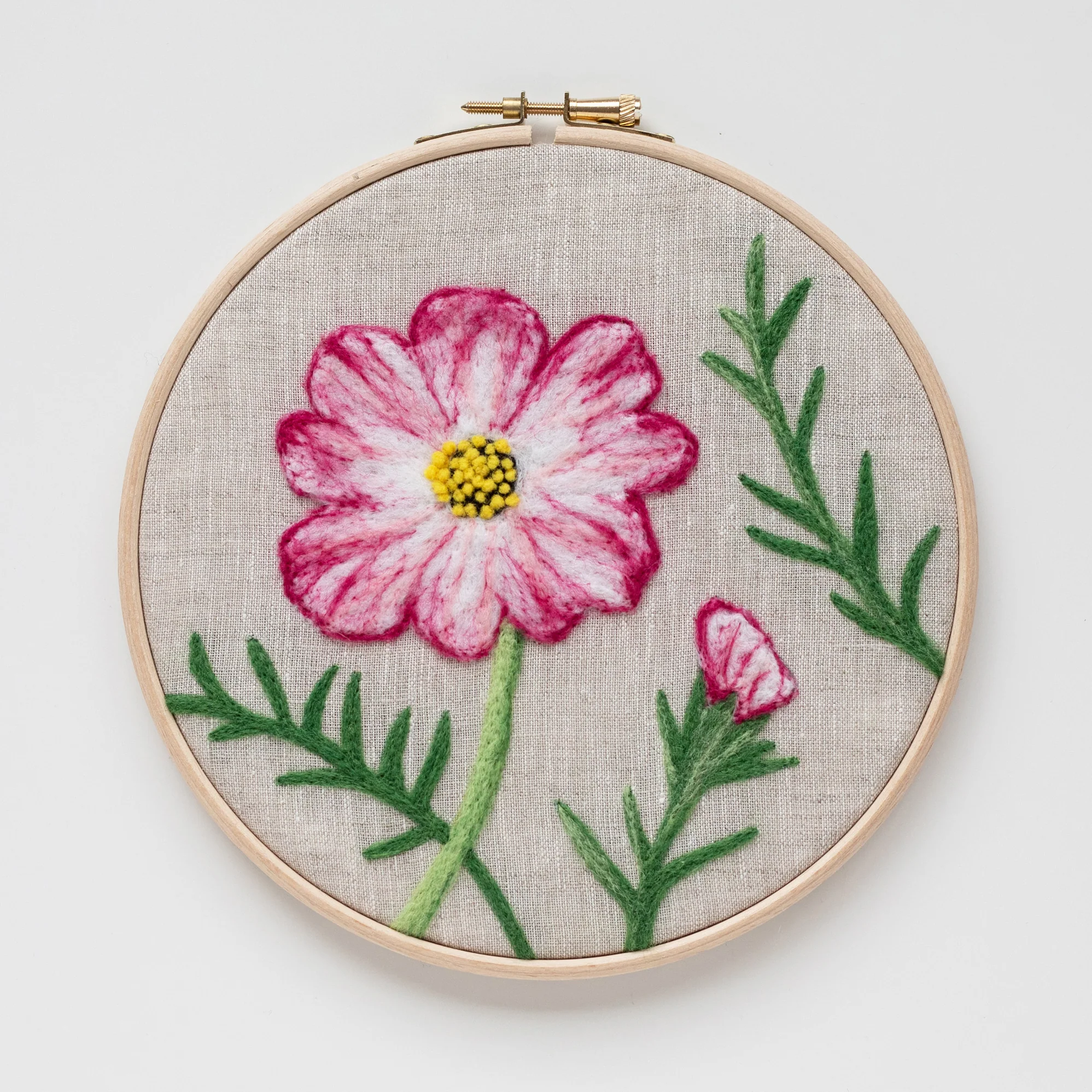 The Cosmos Flower Needle-felting Kit is embroidered on a hoop.