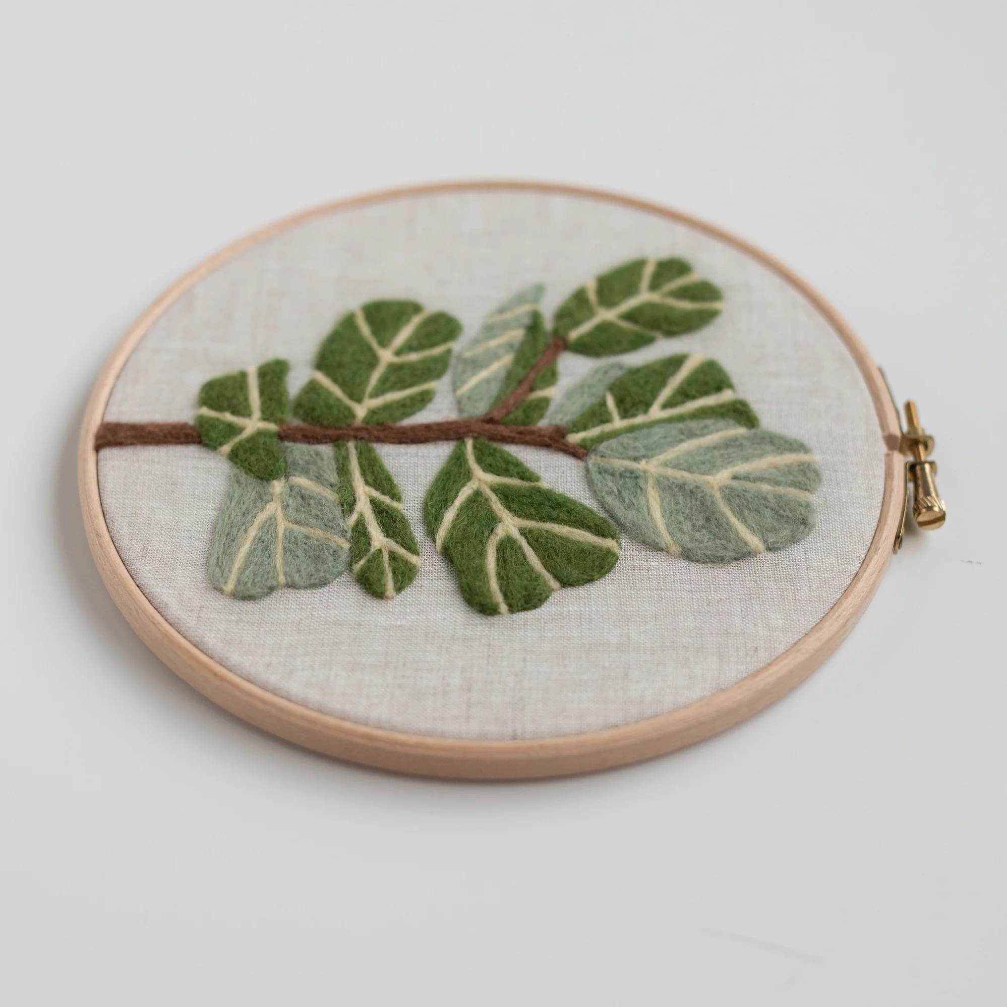 A hoop with a Fiddle-Leaf Fig Needle Felting Kit embroidered on it.