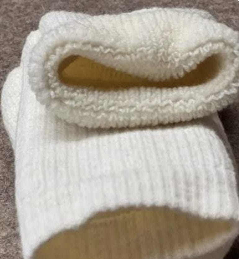 A pair of white socks on top of a carpet.